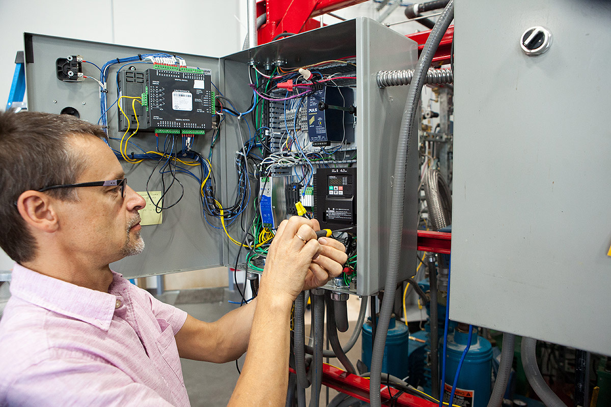 OxEon engineer working on the electrical panel for the Syngas production skid.